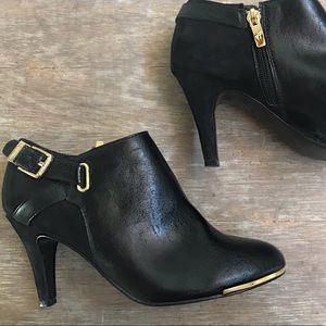 Black leather ankle boots with gold accents